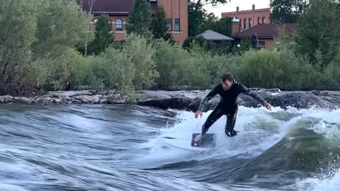 A man surfing a wave in the river.